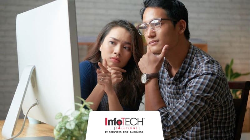 Two employees looking at the same screen while they go through the steps of a disaster recovery testing process.